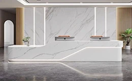 Modern hotel reception desk with a large-format printed quartz surface, showing continuous marble veining in commercial design