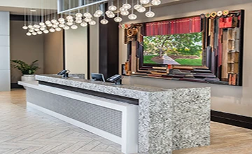 Hotel reception desk with a large-format quartz countertop, showing cost-effective project value slabs in a hospitality setting