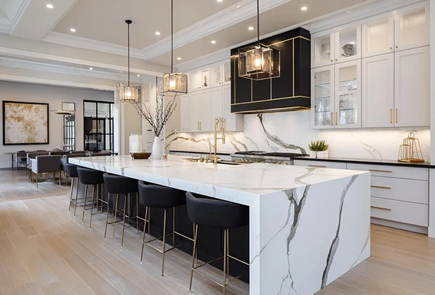 High-end kitchen island countertop in printed Calacatta quartz with continuous marble veining, paired with gold accents for luxury residential projects