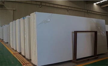 Bright warehouse with neatly stacked solid white classic quartz slabs, demonstrating stable bulk inventory and supply capacity