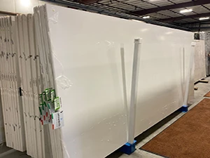 Packed white quartz slabs stored in warehouse, ready for protected delivery to multifamily and commercial projects