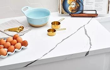 Close-up of durable white quartz countertop surface with grey veining, showing stain and scratch resistant finish for high-traffic projects