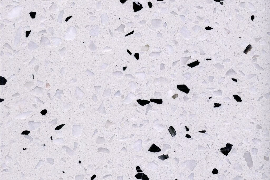 Diamond Pepper terrazzo slab by AsiaQuartz - clean milky-white base with irregular black mineral chips and fine light-grey aggregates for kitchen countertops and wall installations