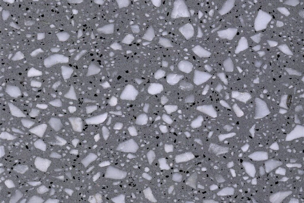 Starry Grey terrazzo slab by AsiaQuartz - cool medium-grey base with creamy-white stone fragments and fine black mineral specks for kitchen countertops and commercial interiors