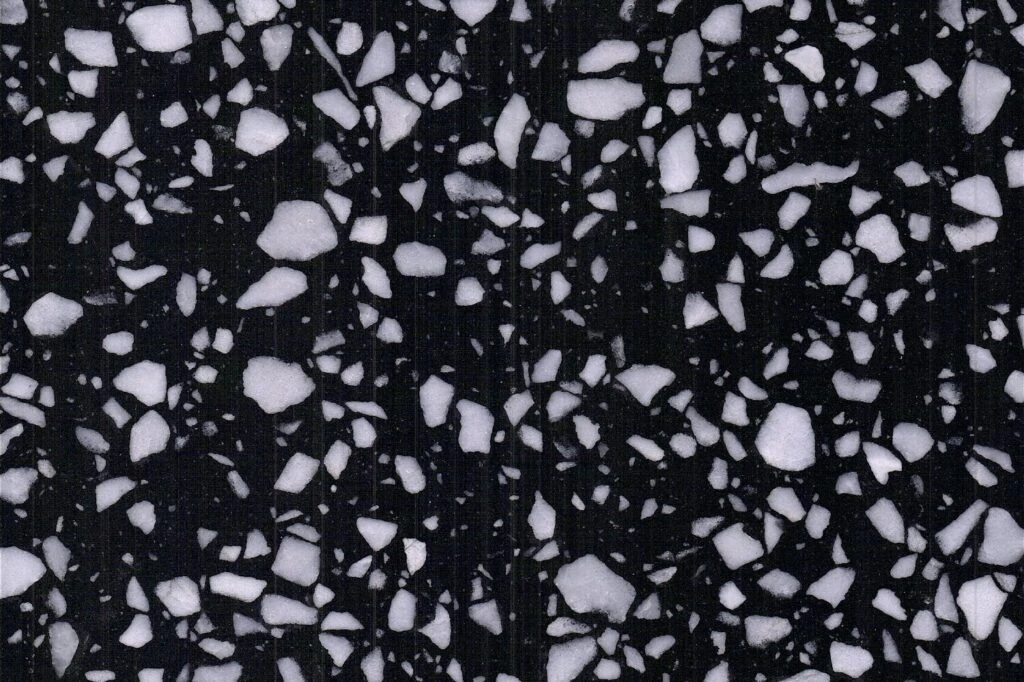 Inorganic Black terrazzo slab by AsiaQuartz - jet-black matrix with dense white mineral aggregates for kitchen countertops and wall cladding